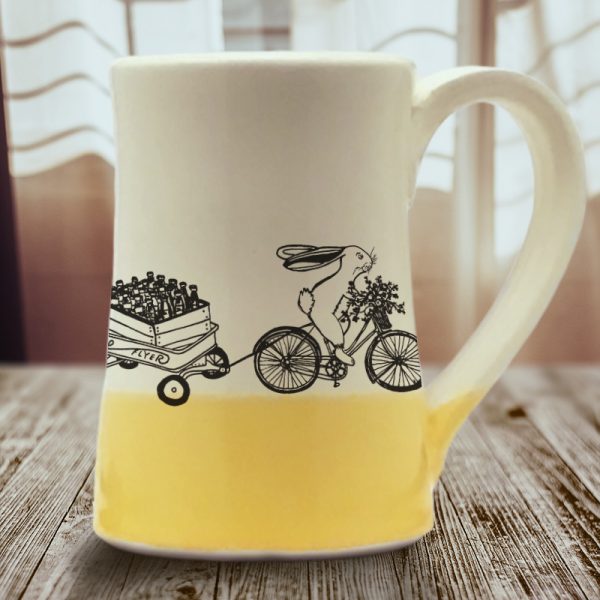 Large coffee mug handmade by hedgehogs with an illustration of yet another Ale on Wheels delivery person. This rabbit is new and not particularly fast. Gold accent color