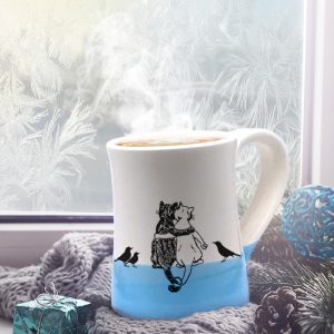 Handmade coffee mug with a drawing of a black cat, a white cat and a few blackbirds quietly enjoying each other's company. Blue accent color