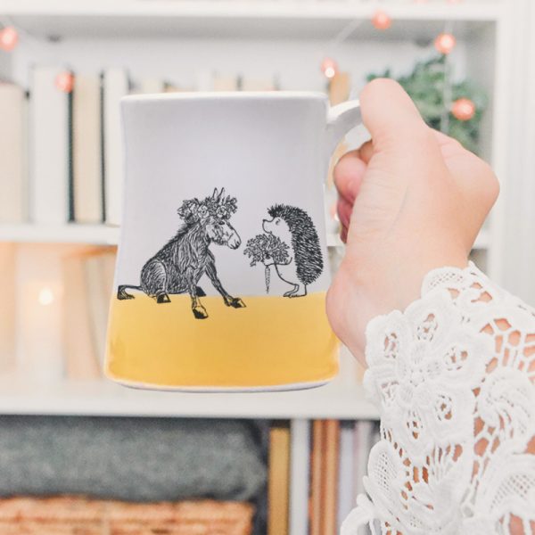 Just a sweet handmade mug with a roguish hedgehog offering a luscious carrot to a donkey princess. Gold accent color.