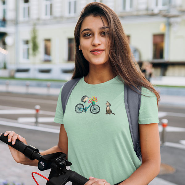 Woman wearing graphic T-shirt with original drawing of a hedgehog on a bike delivering flowers to a dog