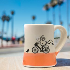 Handmade coffee mug with a drawing of a fox delivering beer on a bicycle. Now what could possibly go wrong? Coral accent color. Handmade coffee mug with a drawing of a fox delivering beer on a bicycle. Now what could possibly go wrong? Coral accent color.