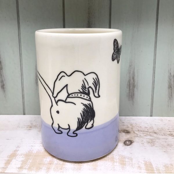 handmade ceramic cup with drawing of a cute dashchund chasing a butterfly