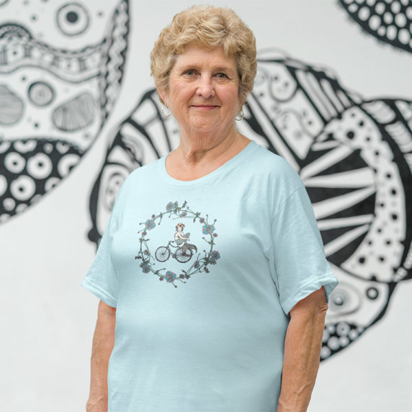 Woman wearing a graphic T-Shirt with original drawing of a mermaid on a bike