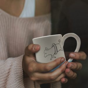 Handmade coffee mug with illustration of a piglet in a life ring bravely diving into shark infested waters. Light blue accent color. Made by hedgehogs in the Blue Ridge Mountains.