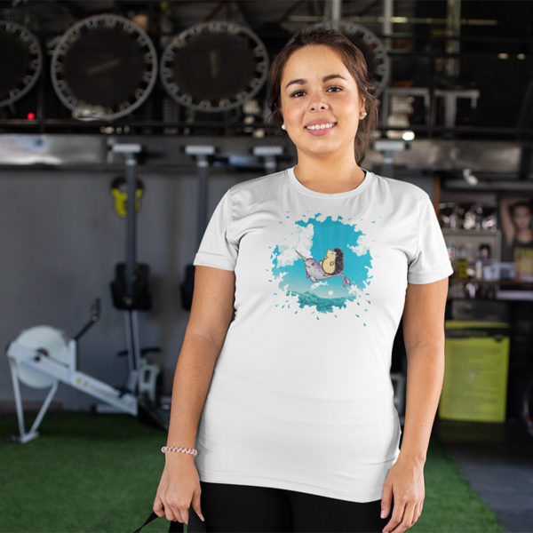 Woman wearing a graphic T-shirt with original drawing of a hedgehog flying over the ocean on the back of a narwhal