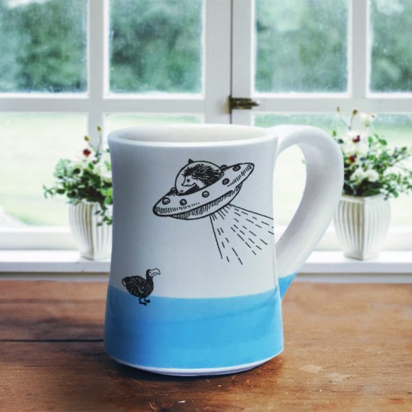 Handmade mug with a typical Darn Pottery illustration of a UFO and a dodo. Blue accent color.