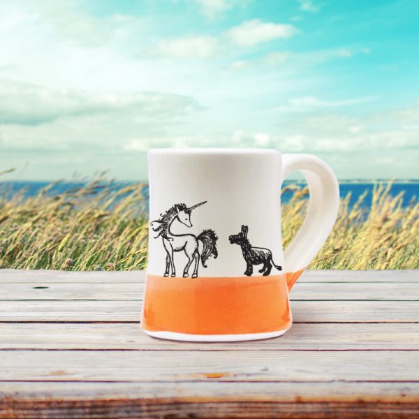 A handmade coffee mug with an illustration of a lovely unicorn and a pathetic little donkey who is in love. Coral accent color.