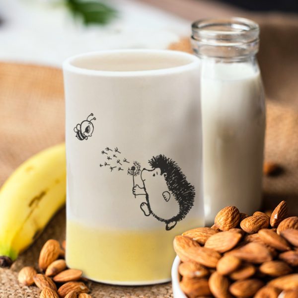 A perfect tumbler for a sunny day, features a drawing of a hedgehog blowing on a dandelion. Gold accent color