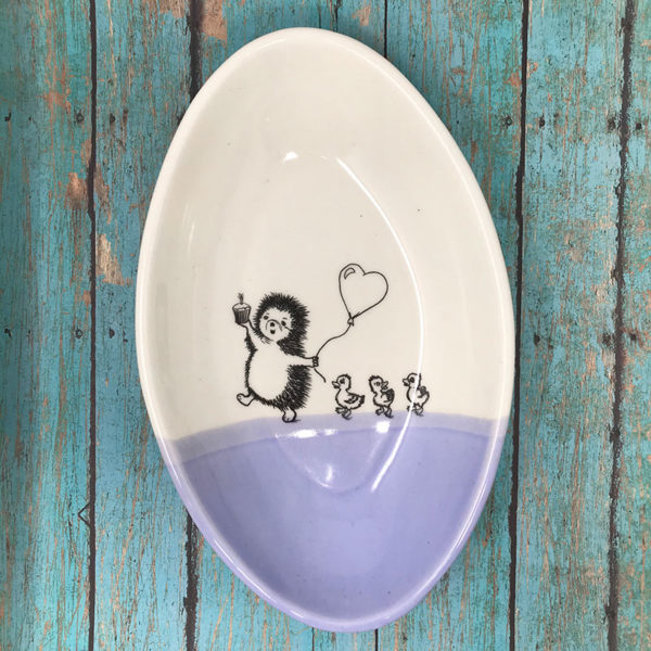 Handmade dish with drawing of a hedgehog leading ducklings to a party