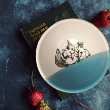 Unlikely best friends, chicken and fox are the featured drawing on this perfect soup bowl that was handmade and illustrated by the hedgehogs of Darn Pottery. Blue accent color.