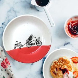 Handmade salad plate with drawing of hedgehog on bike and wagon with gifts. Red accent color