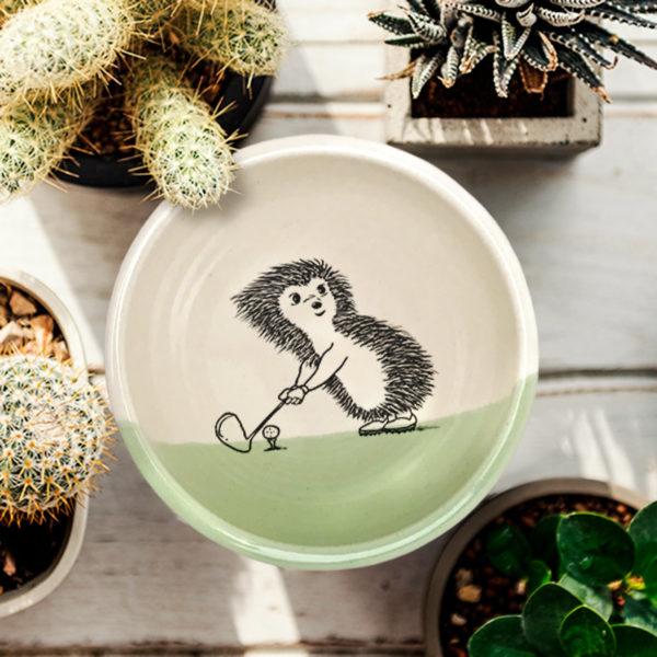 Handmade soup bowl with drawing of a hedgehog golfing.