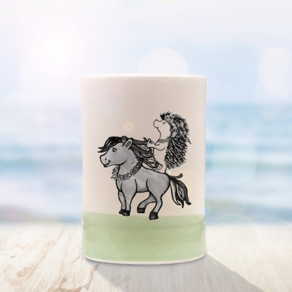 Green Darn Pottery tumbler with drawing of a Hawaiian hedgehog riding a horse wearing a lei