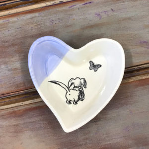 handmade ceramic heart with picture of a dog butt and a butterfly. Made by Darn Pottery with lavender color accents