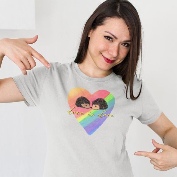 Model wearing a graphic Tshirt illustrated with original Darn Pottery artwork of two hedgehogs on a rainbow heart background with the text Love is Love