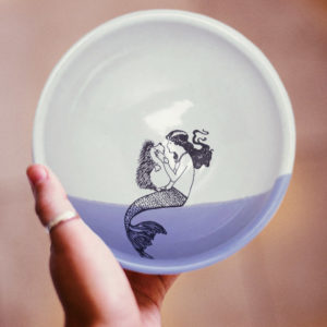 Handmade soup bowl with drawing of a mermaid kissing a hedgehog. Lavender accent color