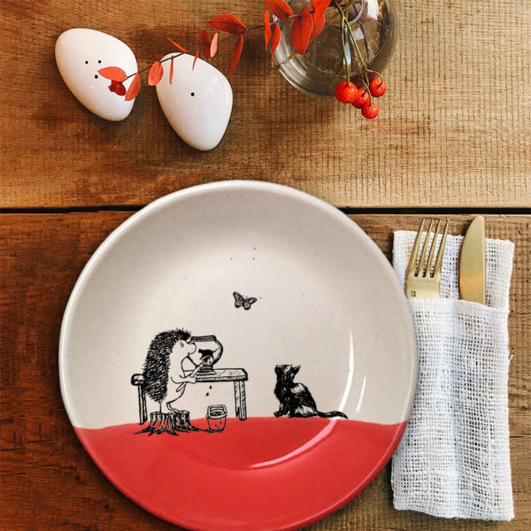 Handmade ceramic plate with drawing of a hedgehog painting a kitten on a pot. Red accent color