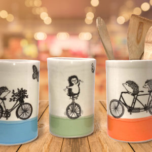 Large utensil holders with drawings of hedgehogs on bikes