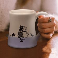 Handmade coffee mug with a drawing of a black cat, a white cat and a few blackbirds quietly enjoying each other's company. Lavender accent color