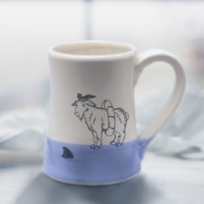 Handmade coffee mug with a drawing of a goat reconsidering his impulsive decision to swim with the sharks. Lavender accent color.