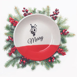 Handmade salad plate with drawing of a little bee in a Santa hat and the word Merry. Red accent color.
