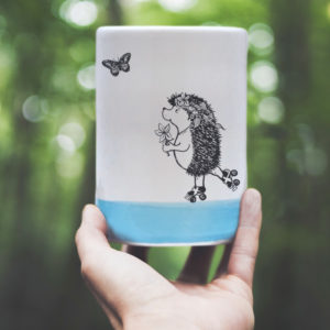 Handmade custom tumbler with drawing of a rollerskating hedgehog. Blue accent color