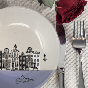 This ceramic plate is handmade by hedgehogs at Darn Pottery and has a drawing of Amsterdam canal houses and a little paper boat. Lavender accent color