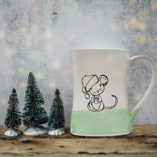 Handmade coffee mug with illustration of a little mouse in a Santa hat. Green accent color