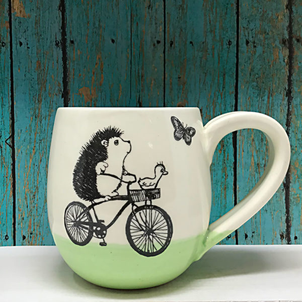 Handmade cocoa mug with original illustration of a hedgehog on a bike