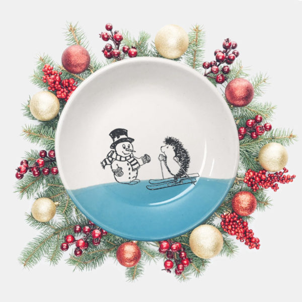 Handmade salad plate with a drawing of a hedgehog on skis greeting a well-dressed snowman. Blue accent color