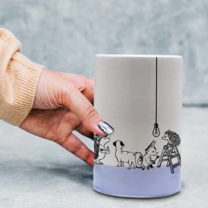 This handmade ceramic tumbler tells the epic tale of an attempt by a rag-tag group of woodland animals to replace a tired, though not quite dead, lightbulb. Lavender accent color.