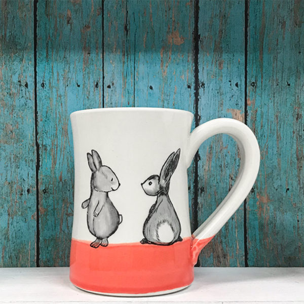Handmade ceramic mug with drawing of two cute rabbits. Red accent color