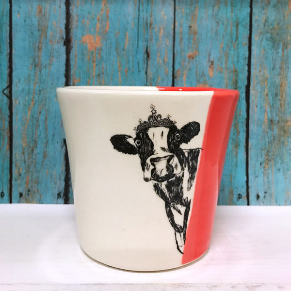 handmade tumbler with drawing of a cow peeking around a corner. Red accent color
